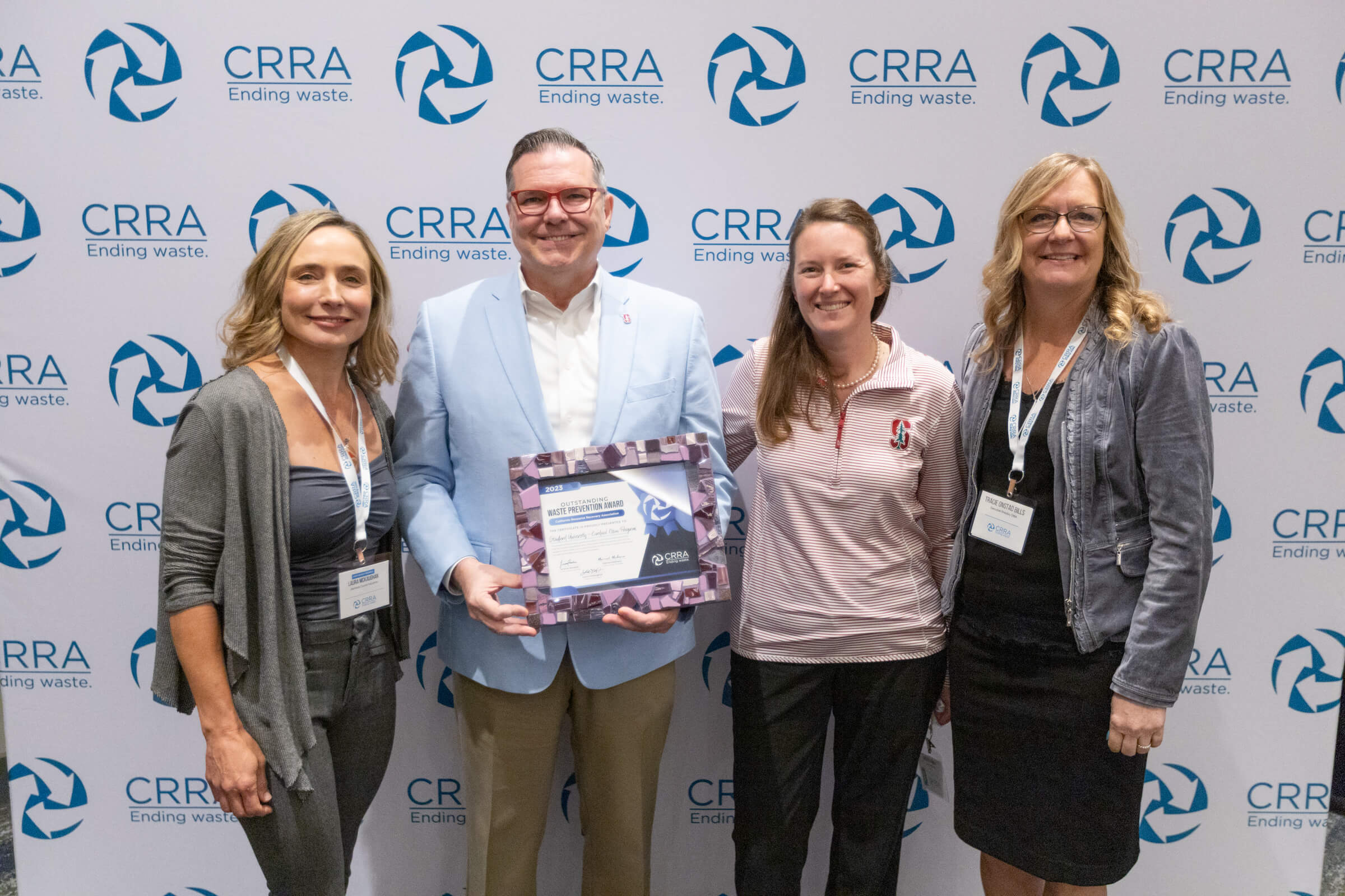 Four people standing holding award