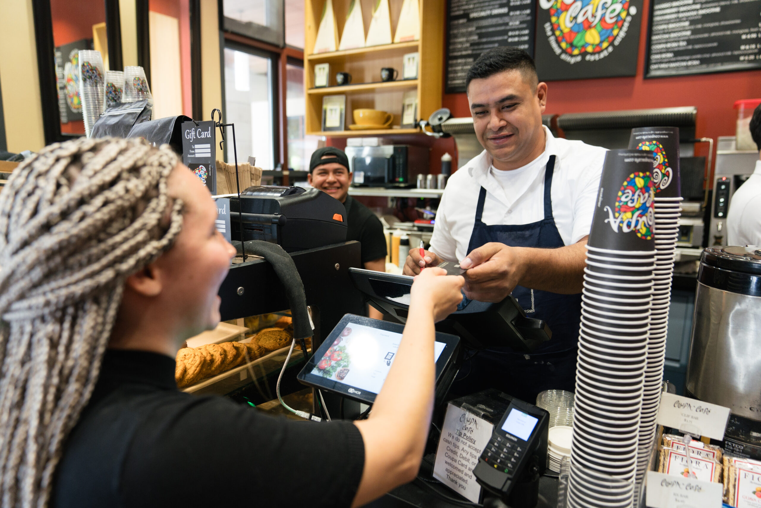 Person at cash register at Coupa Cafe