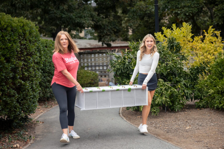 Mom and daughter carrying furniture in for move in