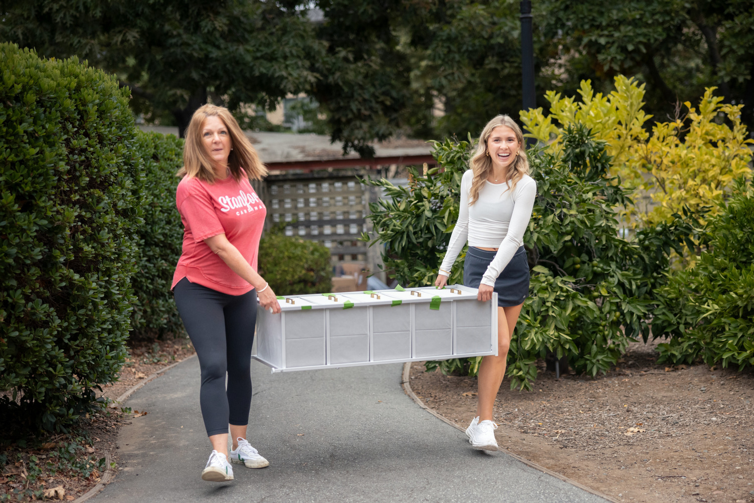 Mom and daughter carrying furniture in for move in