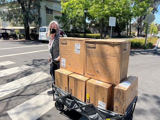 Person pulling a wagon full of boxes of bins.
