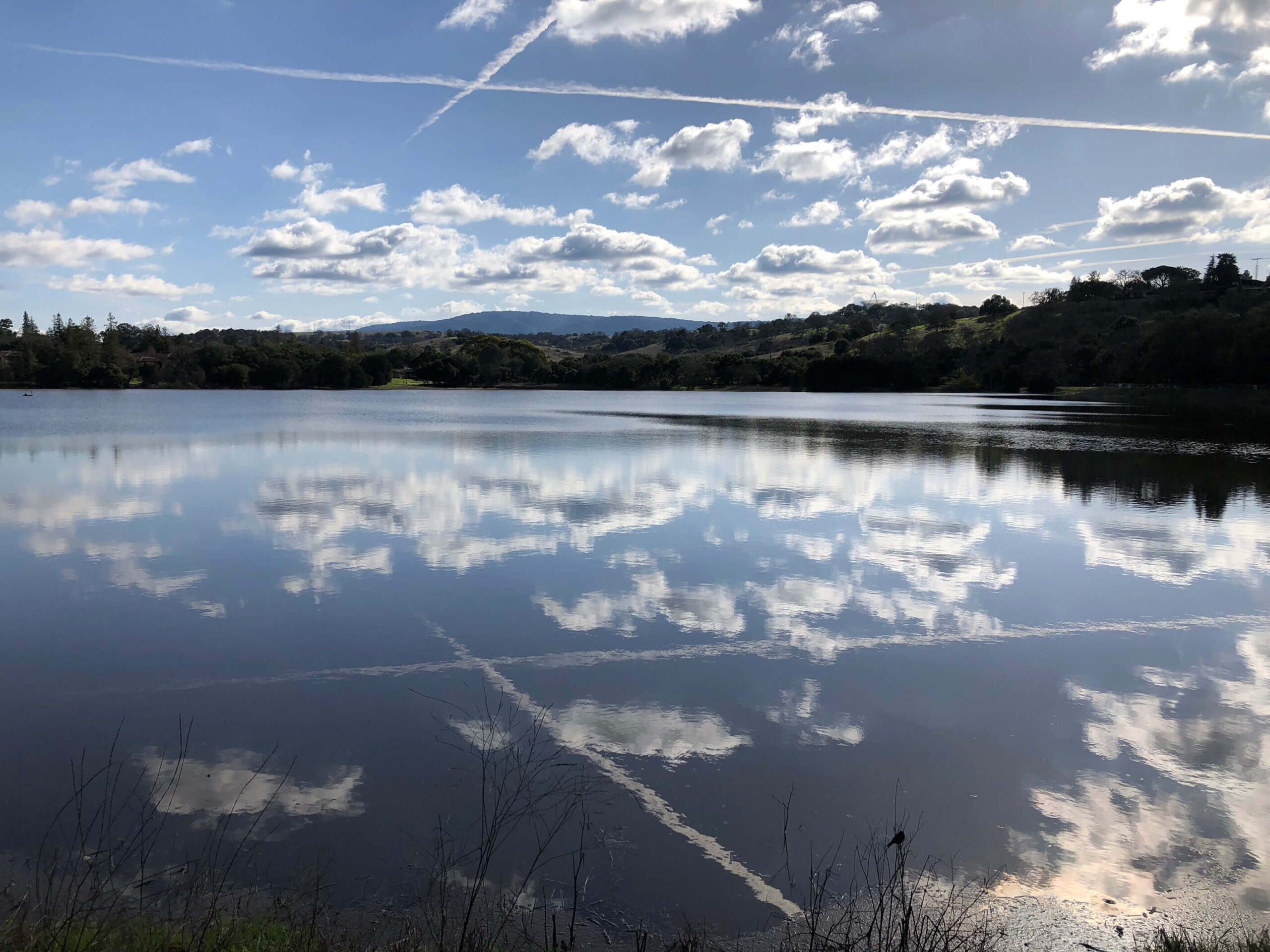 Image of lake with blue sky and mountains behind