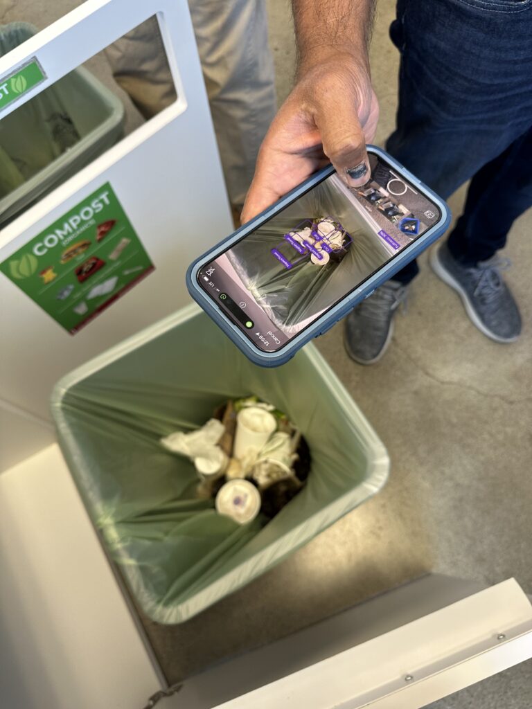 Person taking a photo of the contents of a compost bin on their phone