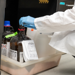Lab worker with brown chemical bottle