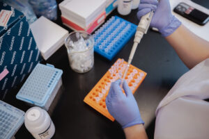Lab personnel refilling a pipette while wearing gloves