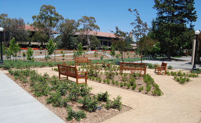 Park with landscaped slope, walkways, benches, and light fixtures