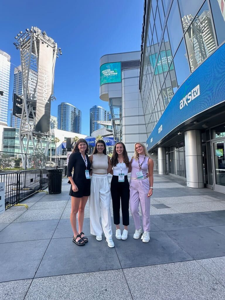 Nora Goodwillie and Sophia Sanders, student designers of the Sustainability in Athletics course, attending the Green Sports Alliance Summit in June 2024, with two students from Duke