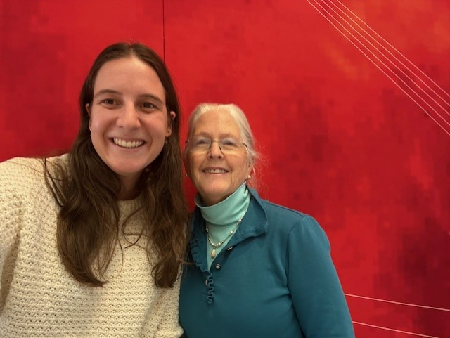 Suki Hoagland with former student in front of red background