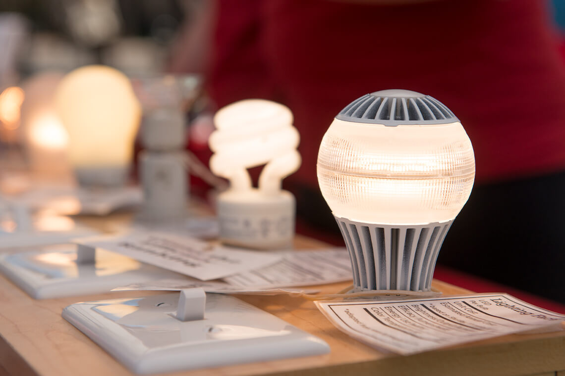 At one of the Sustainable Stanford information tables, a display of light bulbs is used to educate the community about energy consumption.