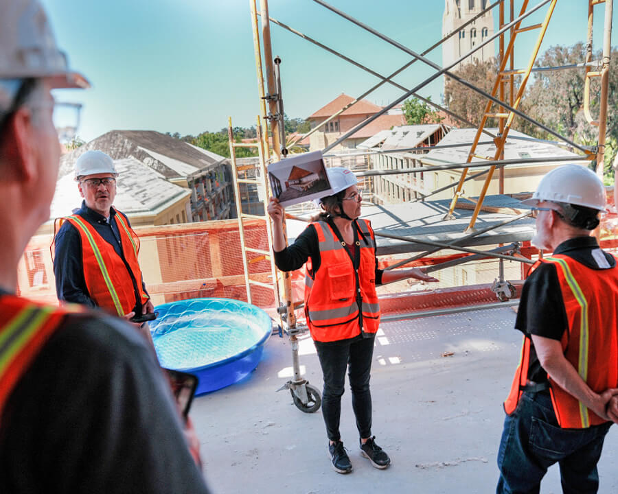 Group in hard hats and neon vests in construction area on campus