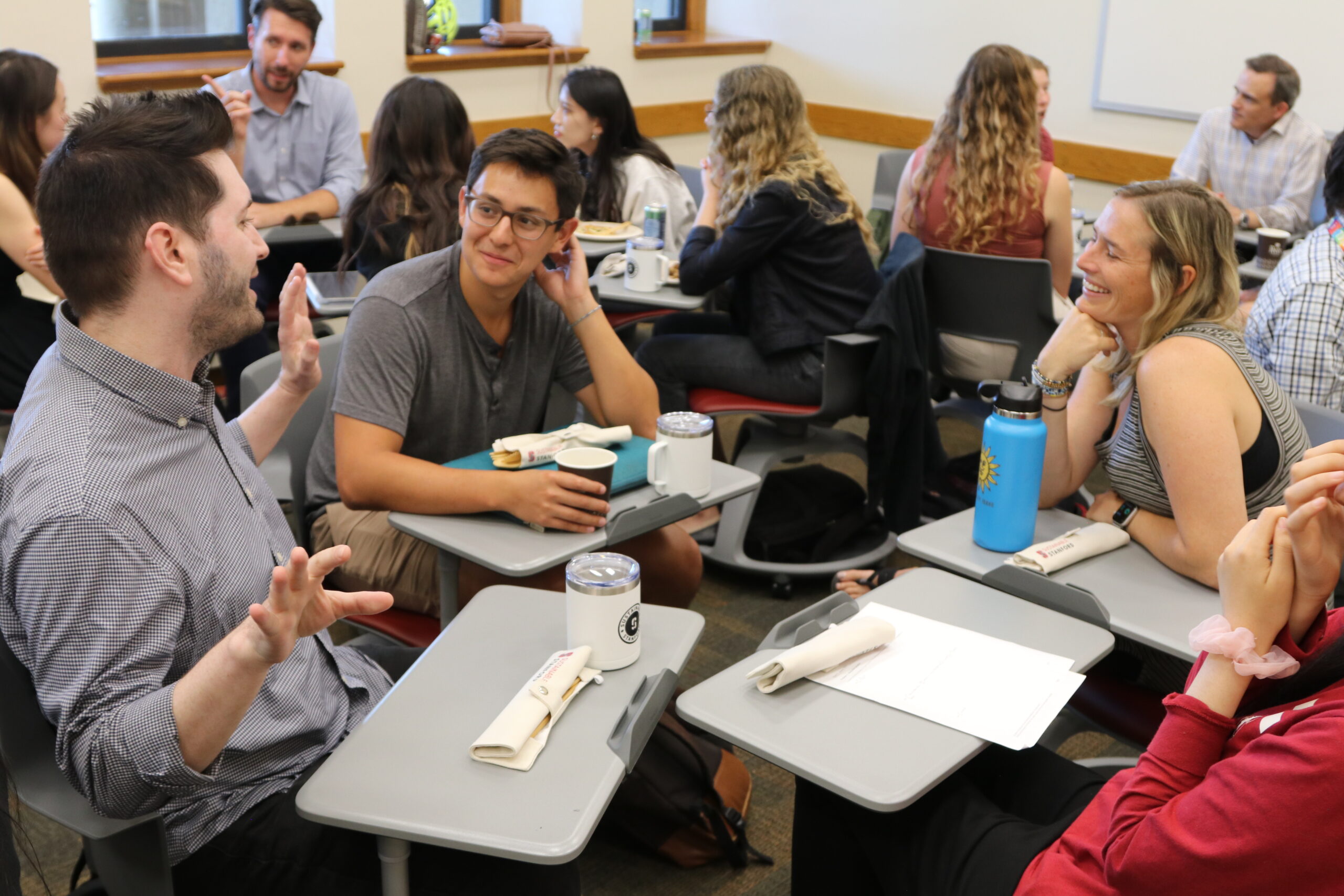 Students and staff in conversation in a classroom during SUSTAIN 120: Leading Organizational Change for Sustainability