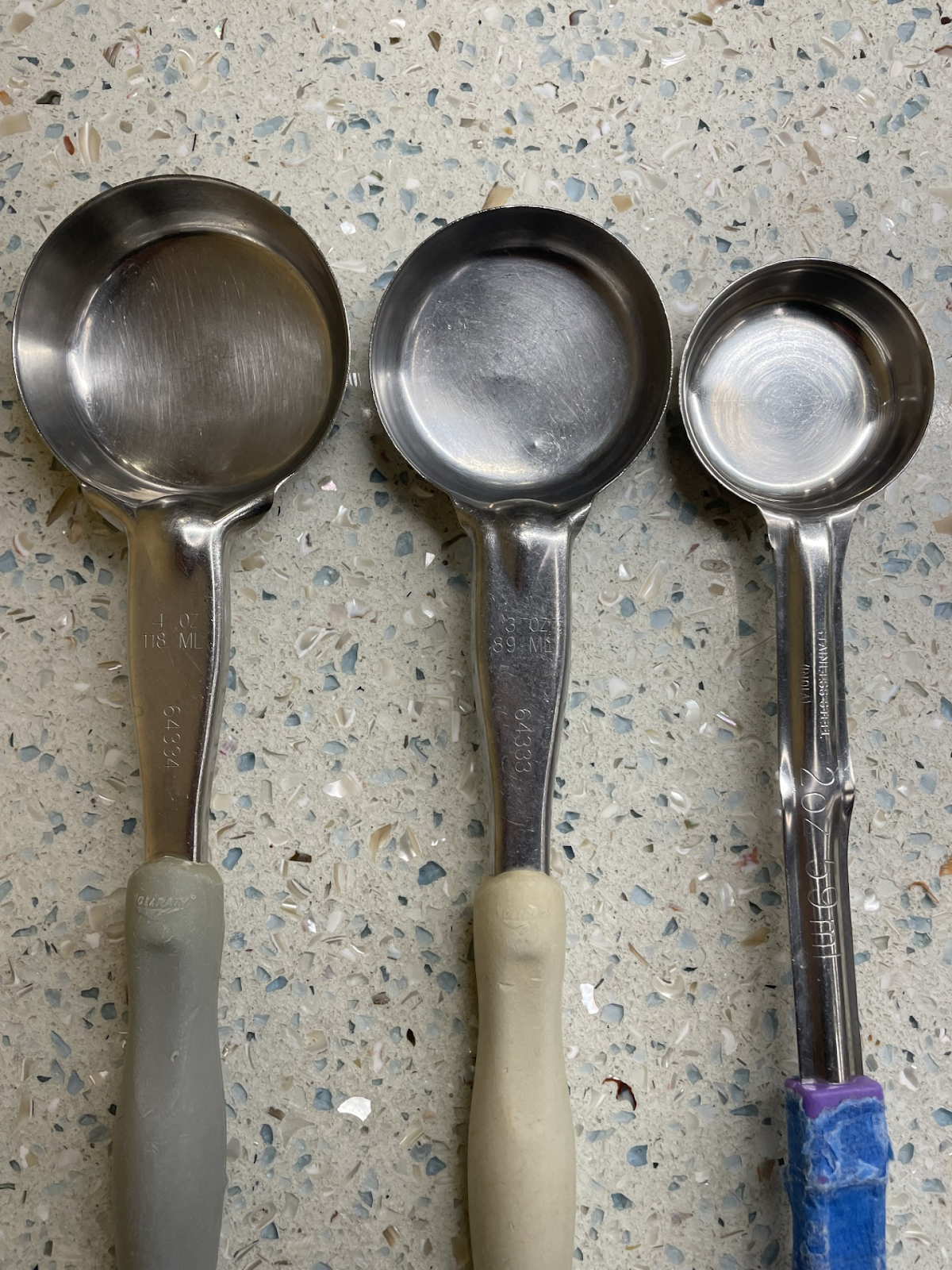 Spoons of varying sizes lined up next to each other from largest on left to smallest on right