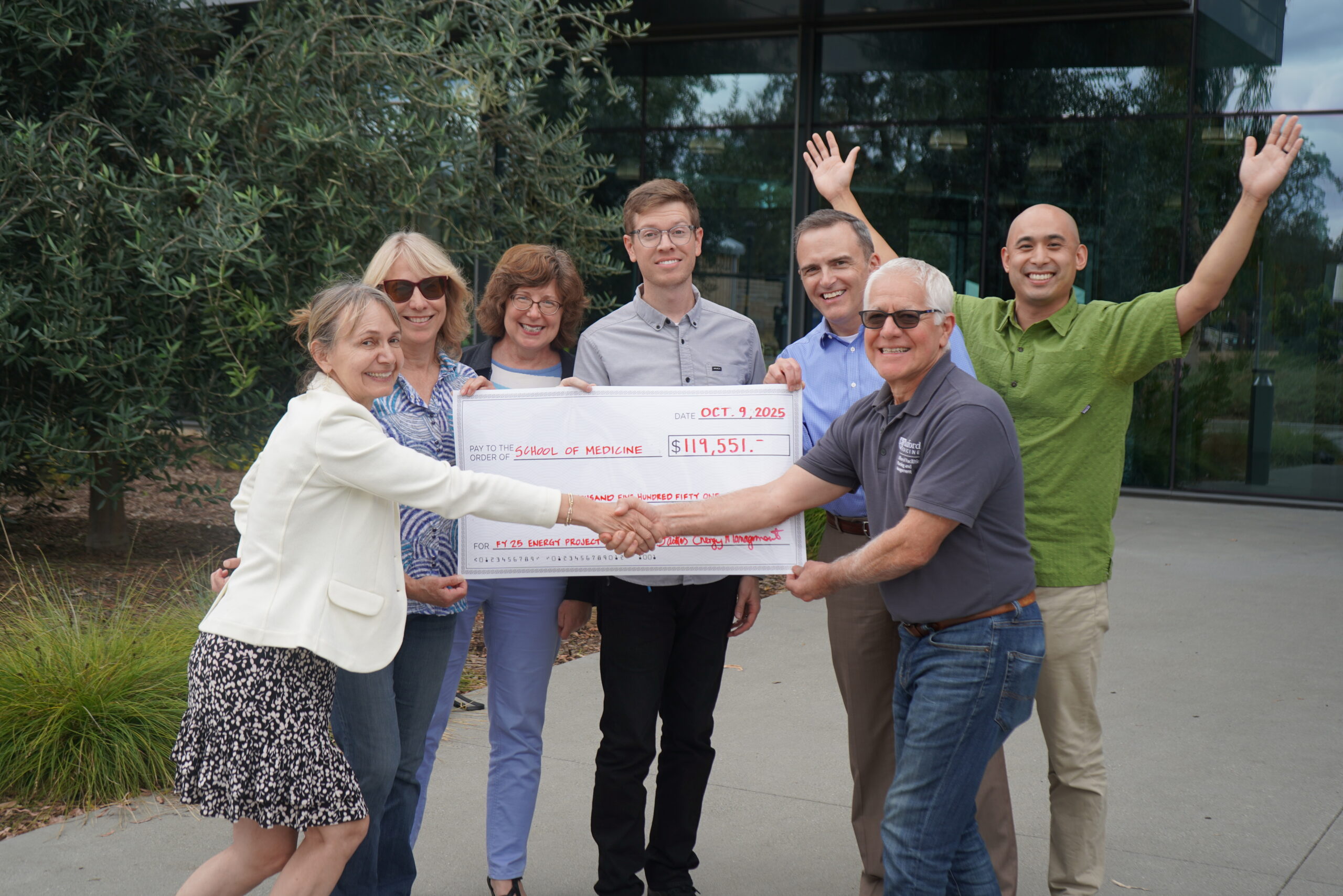 The School of Medicine Office of Facilities Planning and Management receiving a big check from Facilities Energy Management team